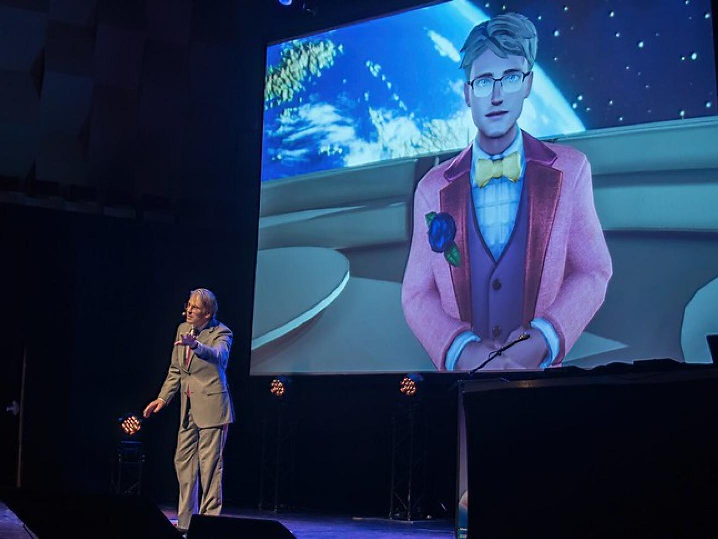Benjamin de Wit op het podium staand voor een groot scherm met daarop zijn avatar tijdens Immersive Tech Week 2022