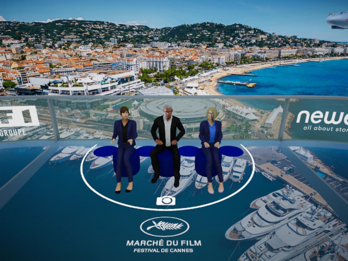 Screenshot uit het virtuele platform Newen Meta Sky,met daarop drie virtuele mensen en als achtergrond de Franse stad Cannes