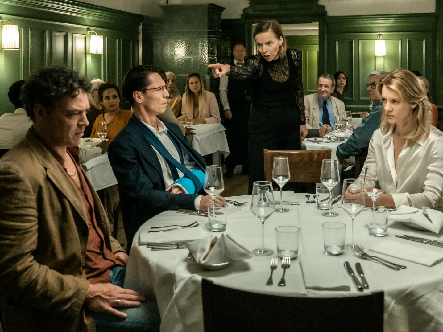 vier ruziënde mensen aan een chique eetttafel in een restaurant