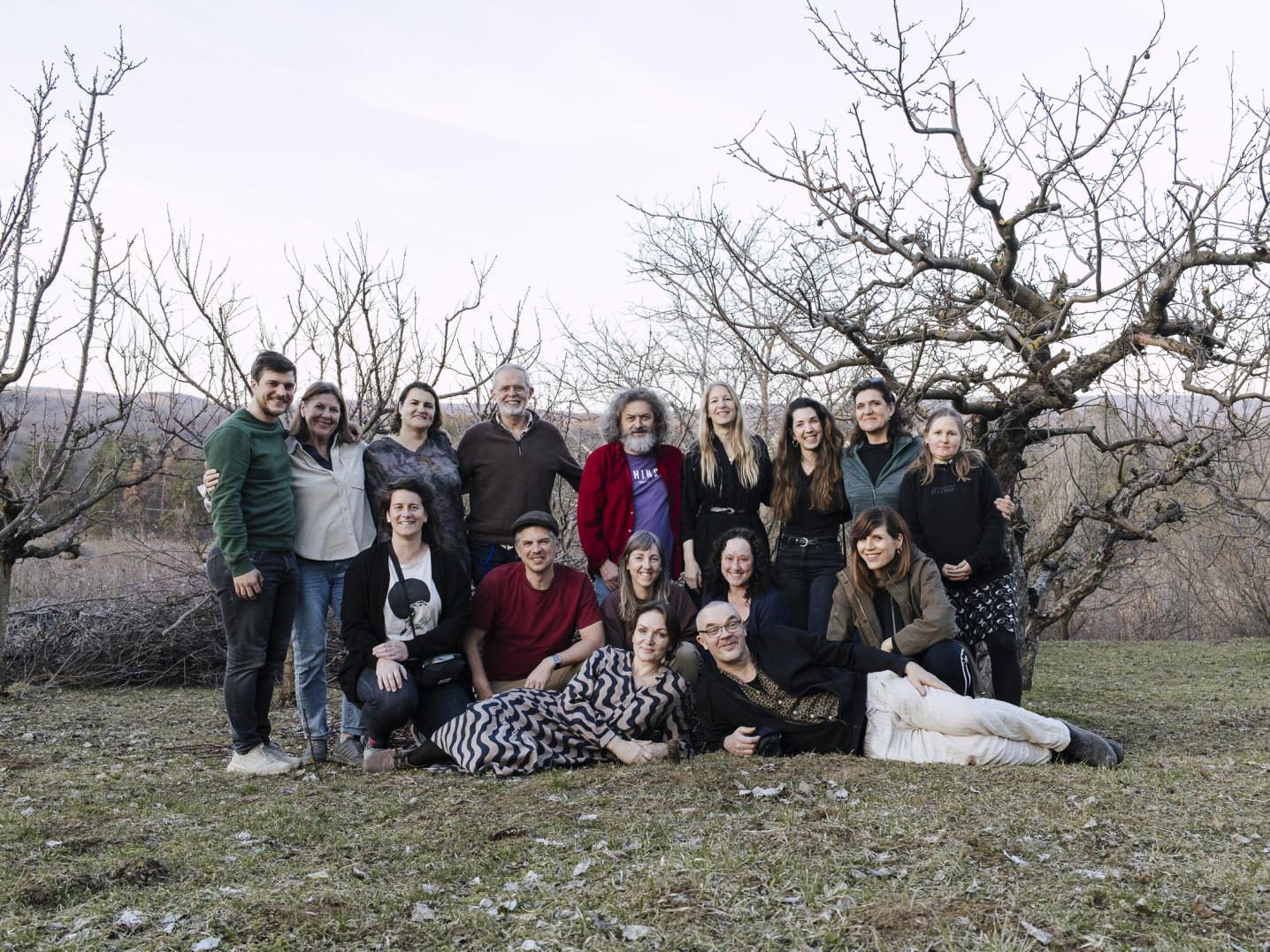 Group of people posing in front of dead trees