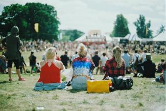 3 vrouwen zitten op festivalterrein