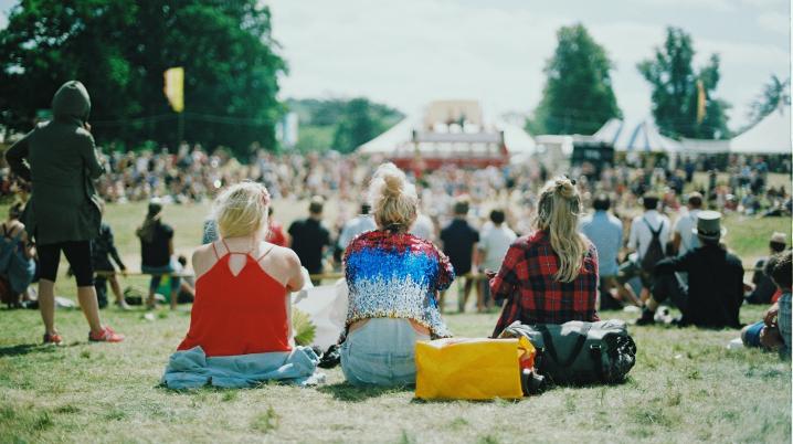 3 vrouwen zitten op festivalterrein