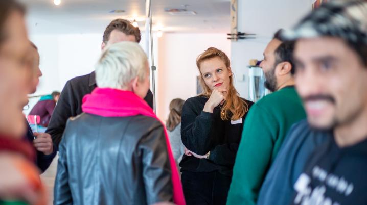 A group of people standing in a room talking