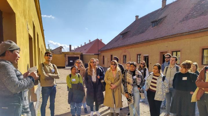 Group of young people standing in a street and listening to someone on the left