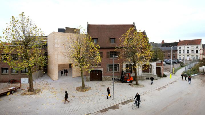 a square with trees, people walking and a bike, with a view on the bulding of the Buda Arts Centre in Kortrijk, Belgium